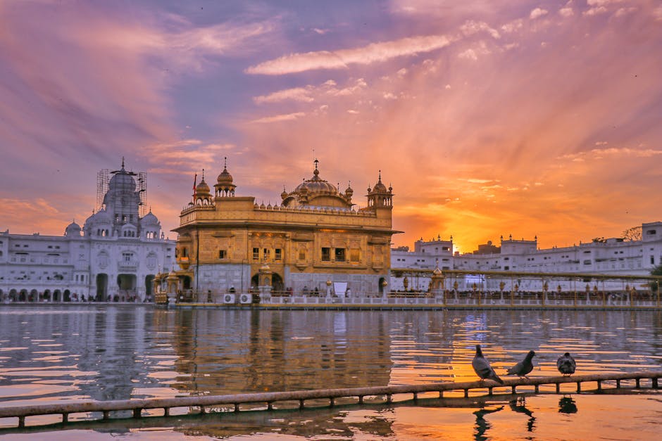 pexels-photo-5458388-5458388 Exterior of Sikh gurdwara golden temple with dome located near water against cloudy sky in evening time in city in India